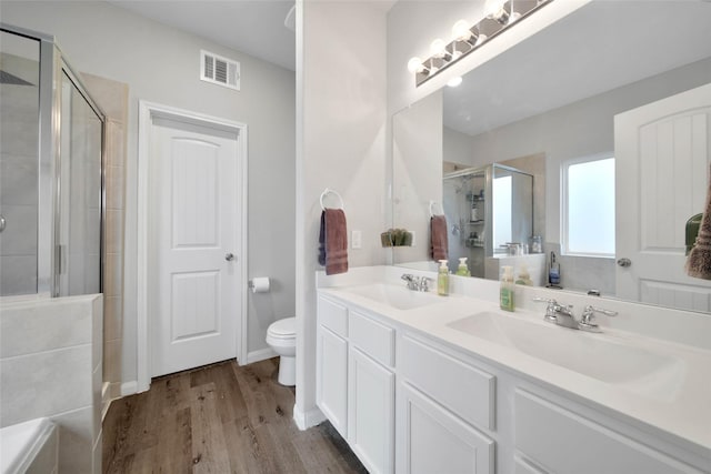 bathroom with vanity, wood-type flooring, toilet, and walk in shower