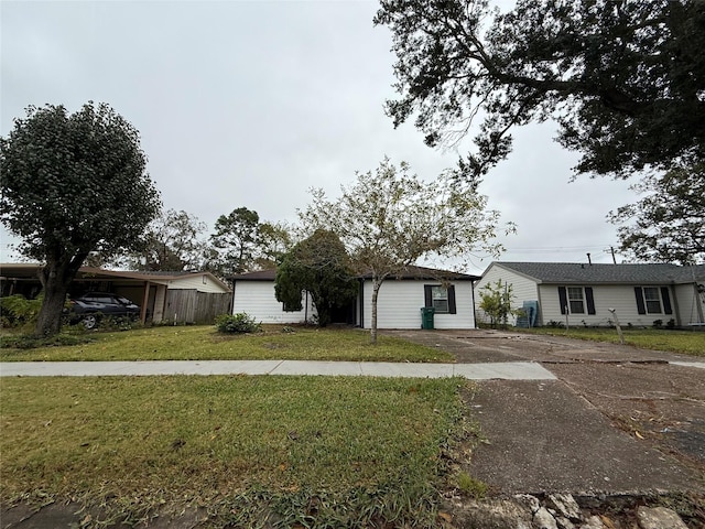 ranch-style house with a carport and a front lawn