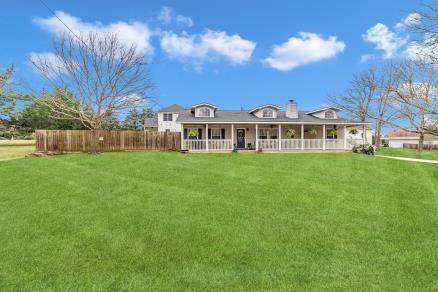 back of property with a porch and a yard