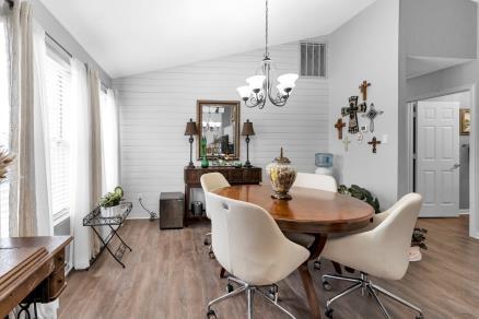 dining room featuring light hardwood / wood-style floors, an inviting chandelier, and vaulted ceiling