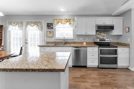 kitchen featuring plenty of natural light, stainless steel appliances, white cabinets, and sink