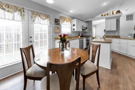 dining room with vaulted ceiling and dark hardwood / wood-style floors