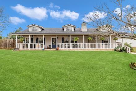 view of front facade with fence, a chimney, and a front lawn