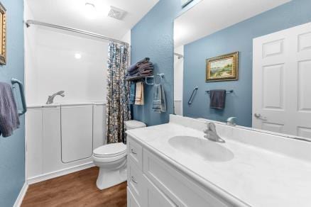 bathroom with toilet, a shower with shower curtain, vanity, and hardwood / wood-style flooring