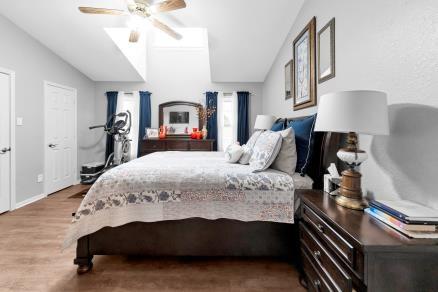 bedroom featuring lofted ceiling, ceiling fan, and wood-type flooring