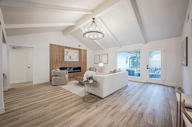 living room featuring an inviting chandelier, lofted ceiling with beams, and wood-type flooring