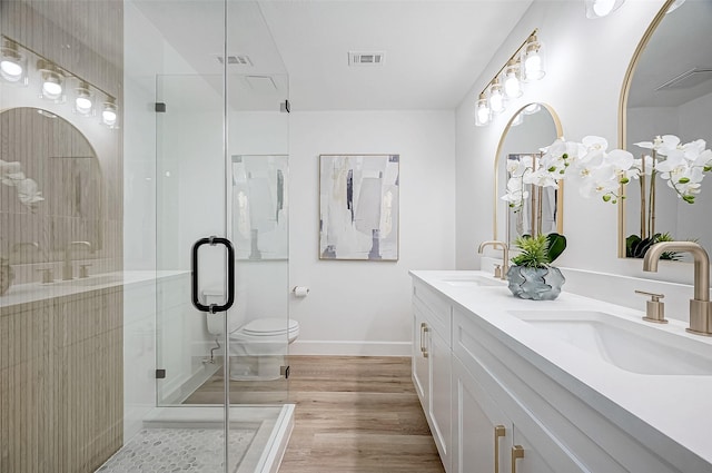 bathroom with walk in shower, hardwood / wood-style flooring, vanity, and toilet