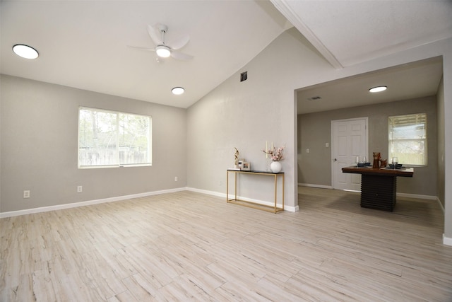 empty room with ceiling fan, vaulted ceiling, and light wood-type flooring