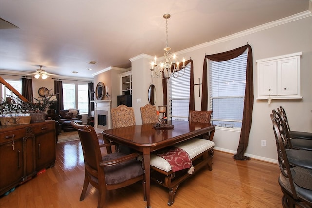 dining room featuring crown molding, ceiling fan with notable chandelier, and light hardwood / wood-style flooring