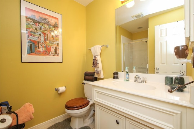 bathroom featuring vanity, a shower with shower door, and toilet