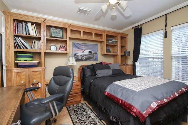 bedroom with ceiling fan, ornamental molding, and hardwood / wood-style floors