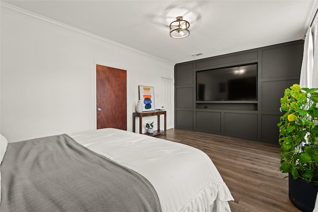 bedroom featuring ornamental molding and dark hardwood / wood-style flooring