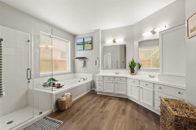 bathroom featuring wood-type flooring, independent shower and bath, and vanity