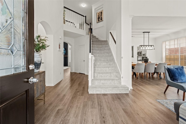 entrance foyer with crown molding and light hardwood / wood-style flooring