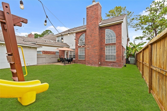 back of house with a patio, a playground, a yard, and central AC