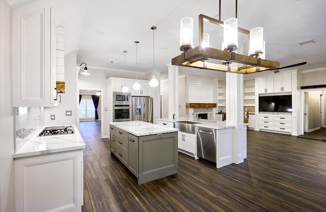 kitchen featuring white cabinets, stainless steel appliances, backsplash, and hanging light fixtures