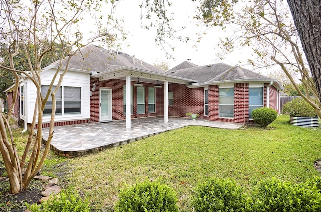 rear view of house with a patio area, ceiling fan, and a lawn