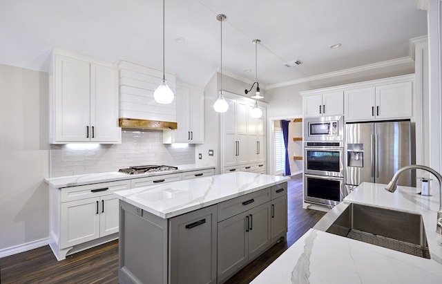 kitchen featuring light stone counters, dark hardwood / wood-style floors, hanging light fixtures, stainless steel appliances, and white cabinets