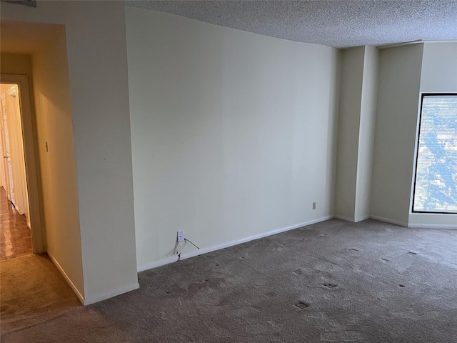 carpeted empty room with a textured ceiling