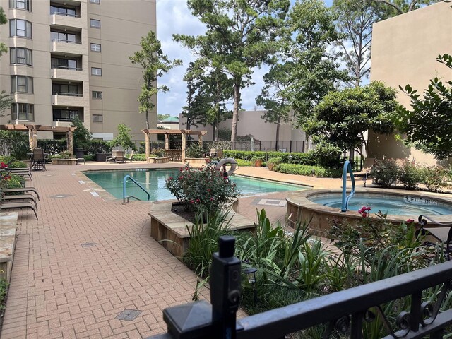 view of swimming pool with a hot tub