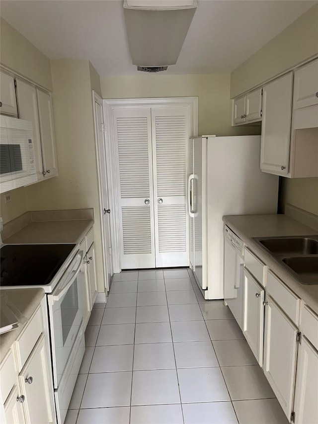 kitchen featuring sink, white appliances, white cabinets, and light tile patterned flooring