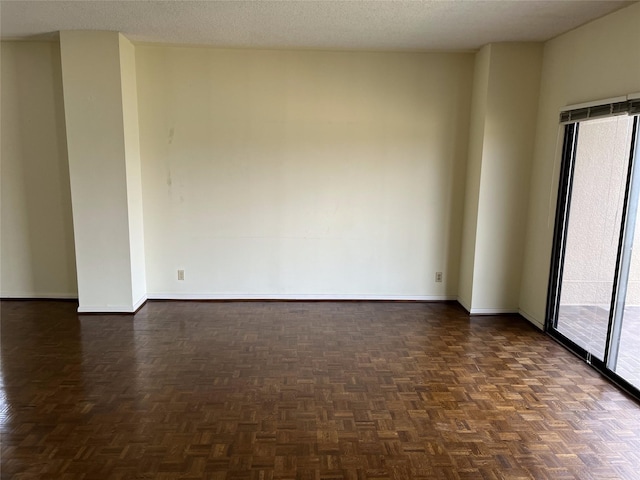 empty room featuring a textured ceiling and dark parquet flooring