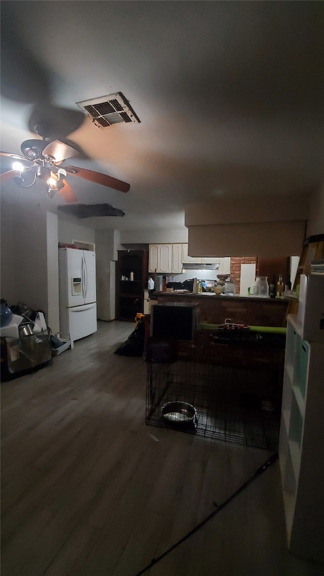 kitchen with wood-type flooring, white fridge with ice dispenser, and ceiling fan