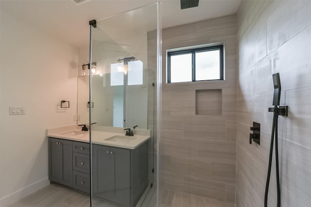 bathroom featuring a tile shower and vanity