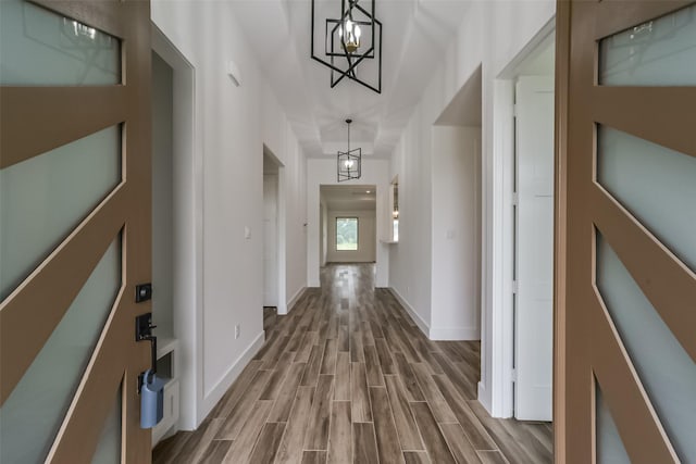 hallway featuring a chandelier and wood-type flooring