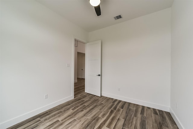 empty room featuring dark hardwood / wood-style flooring and ceiling fan