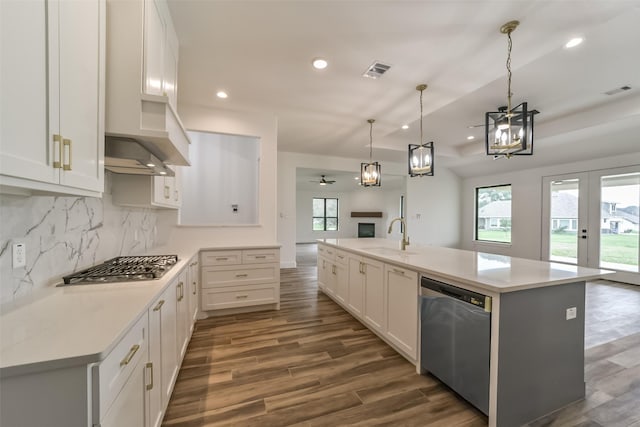 kitchen featuring stainless steel appliances, white cabinets, sink, and a kitchen island with sink