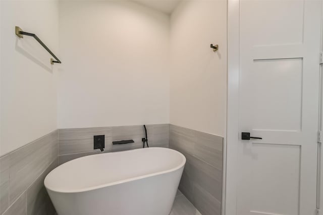 bathroom with tile walls and a bathing tub