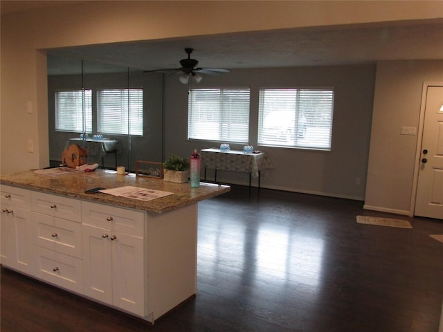 kitchen with decorative light fixtures, white cabinets, ceiling fan, and light stone counters