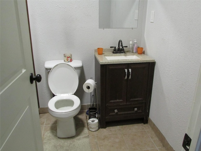 bathroom with tile patterned flooring, vanity, and toilet