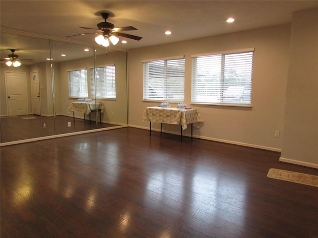 empty room with ceiling fan and dark wood-type flooring