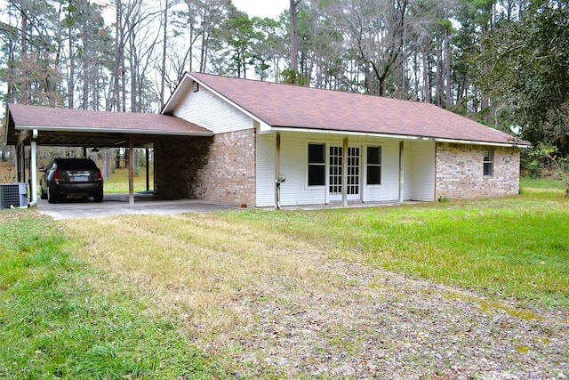 ranch-style home featuring central air condition unit, french doors, a carport, and a front yard