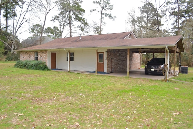 back of house featuring a lawn, central air condition unit, and a carport