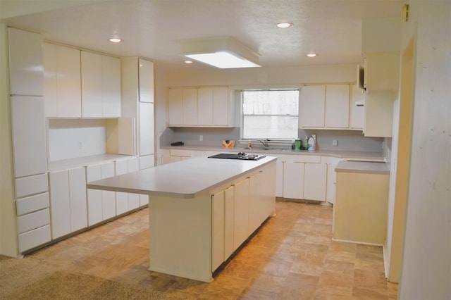 kitchen featuring sink, white cabinetry, and a kitchen island