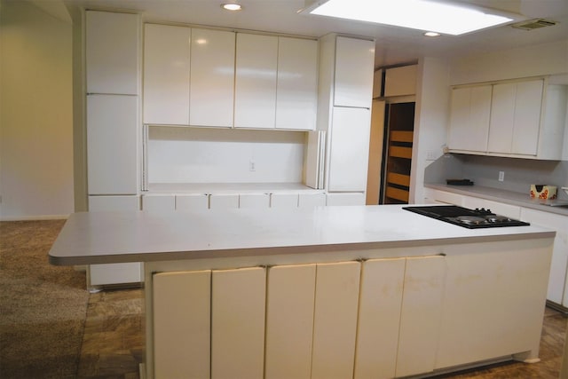 kitchen featuring black gas stovetop, white cabinets, and a center island