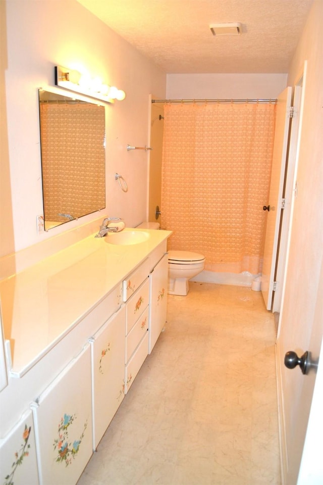 full bathroom featuring toilet, vanity, shower / bath combo with shower curtain, and a textured ceiling