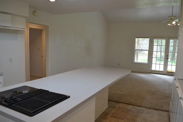 kitchen with ceiling fan, white cabinets, french doors, and carpet