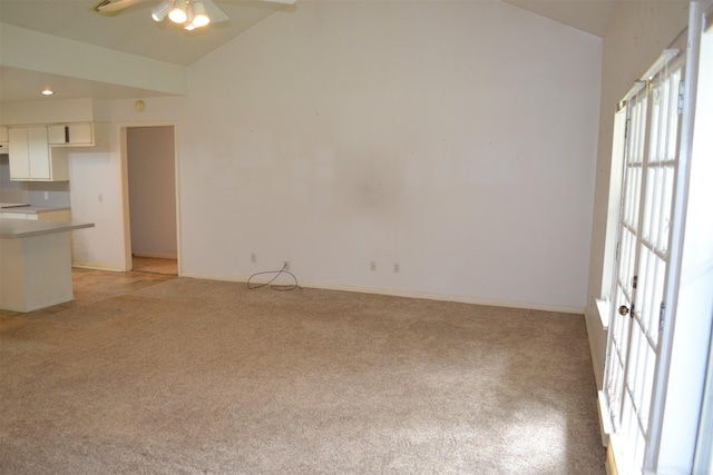 unfurnished living room with lofted ceiling, light colored carpet, and ceiling fan