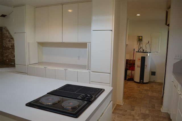 kitchen with black electric stovetop, white cabinetry, and electric water heater