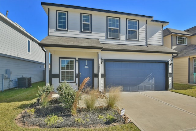 view of front of house with a front lawn, central AC unit, and a garage