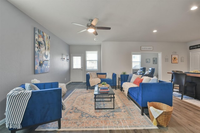 living room featuring wood-type flooring and ceiling fan