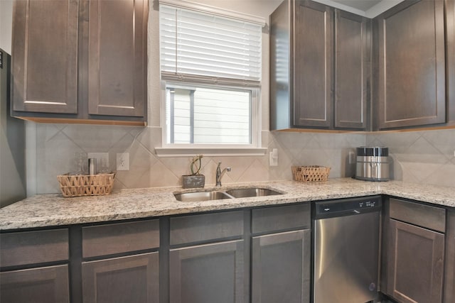 kitchen with sink, stainless steel dishwasher, light stone countertops, decorative backsplash, and dark brown cabinetry