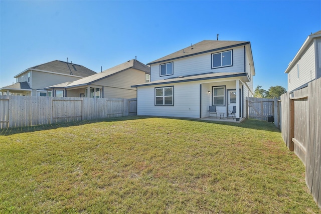 rear view of house with a patio and a lawn