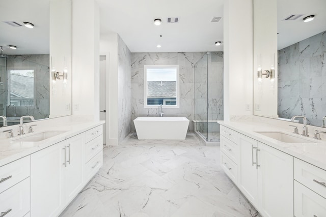 bathroom featuring two vanities, a marble finish shower, and a sink