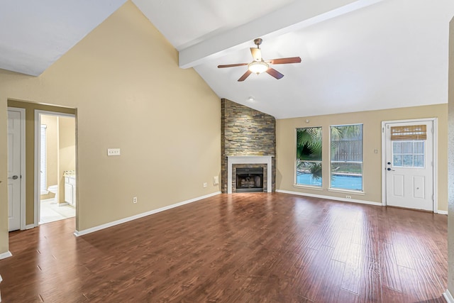 unfurnished living room with hardwood / wood-style flooring, ceiling fan, lofted ceiling with beams, and a stone fireplace