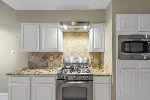 kitchen with light stone counters, stainless steel appliances, decorative backsplash, and white cabinetry